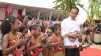 Presiden Jokowi tampak antusias dan mencoba turut serta memainkan ukulele, di Kawasan Pantai Semau, Kabupaten Biak Numfor, Provinsi Papua, pada Kamis (23/11/2023). (Foto: BPMI Setpres/Kris)