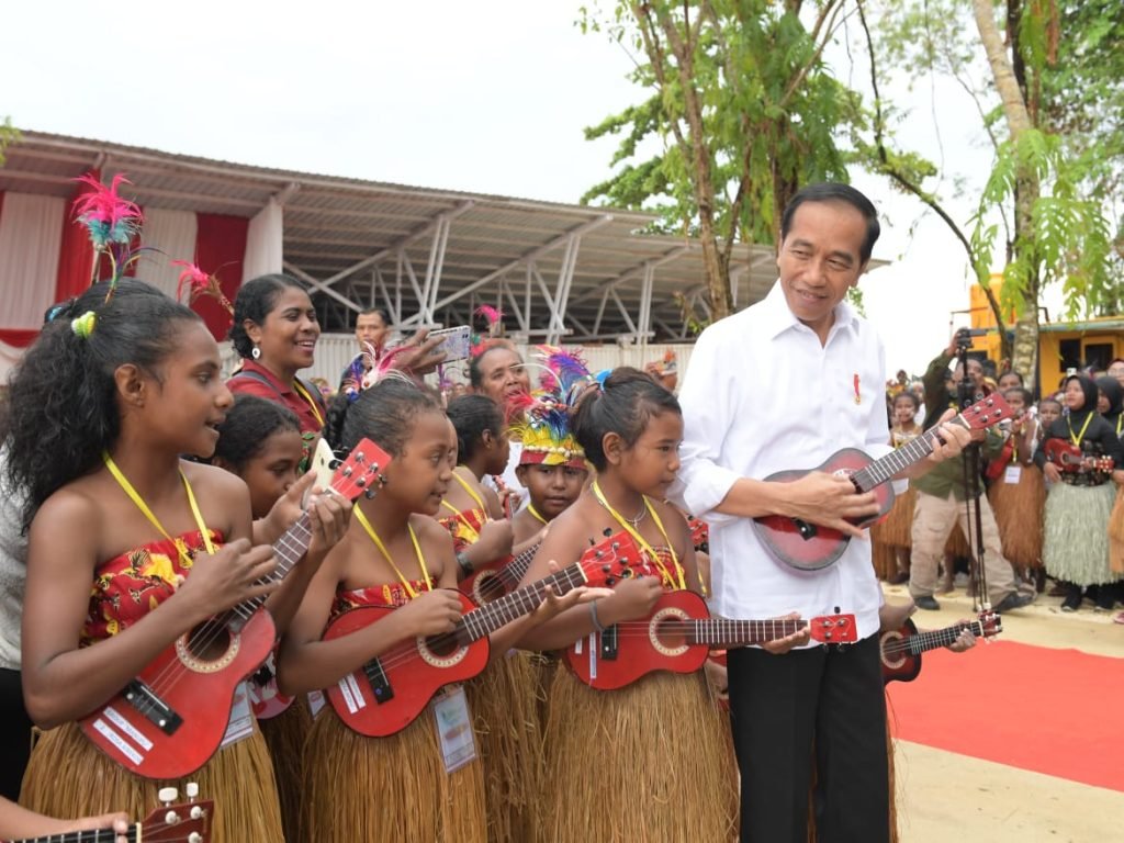 Presiden Jokowi tampak antusias dan mencoba turut serta memainkan ukulele, di Kawasan Pantai Semau, Kabupaten Biak Numfor, Provinsi Papua, pada Kamis (23/11/2023). (Foto: BPMI Setpres/Kris)